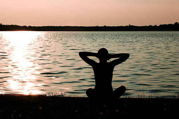 teenage girl doing yoga on lake shore in sunset teenage girl doing yoga on lake shore in sunset